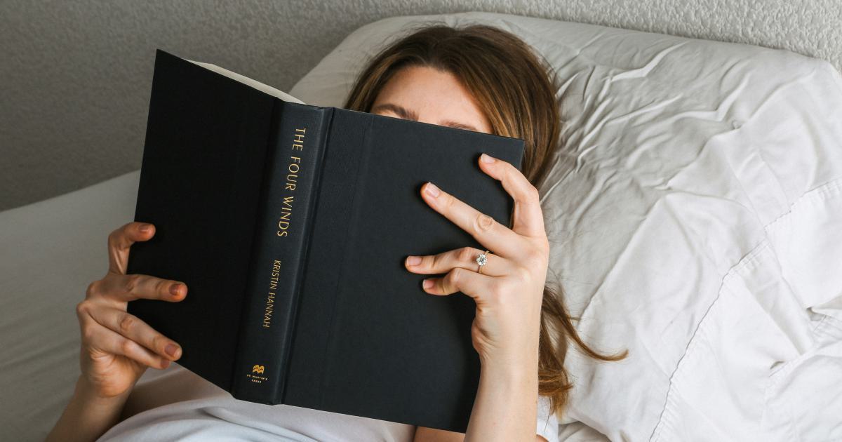 Femme dans son lit avec un livre