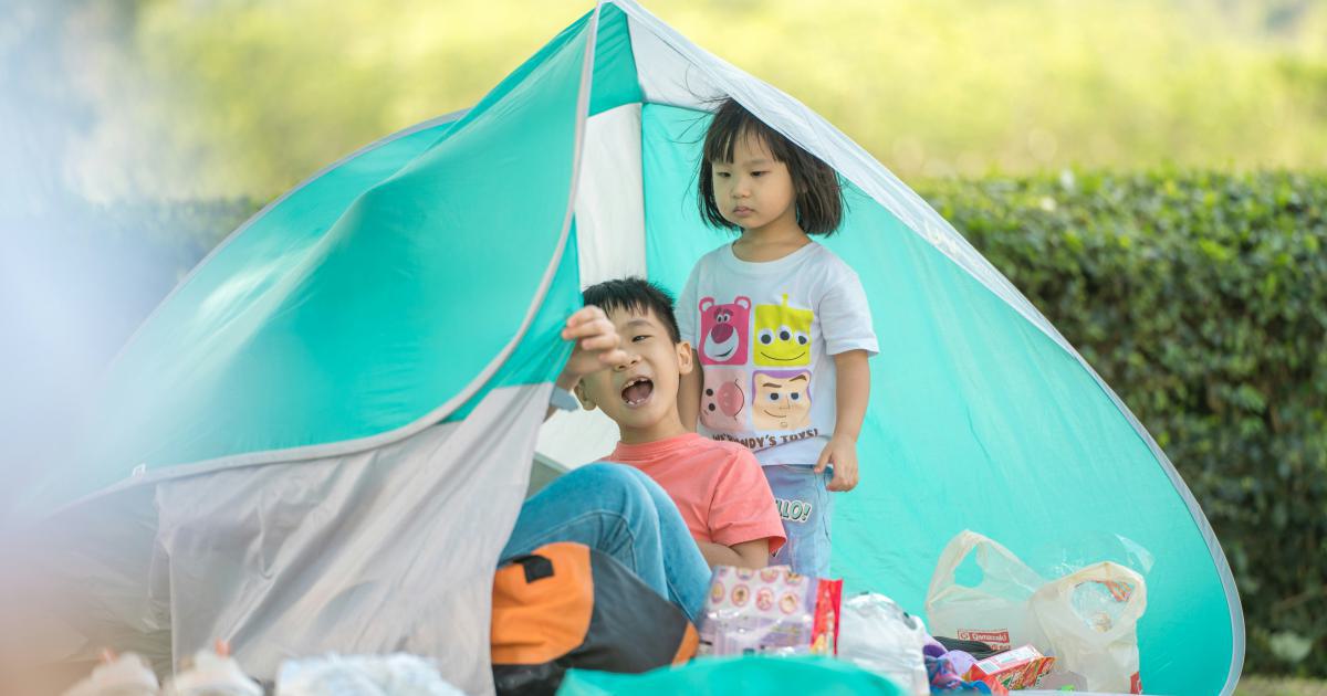 Famille installée dans une tente avec un matelas gonflable
