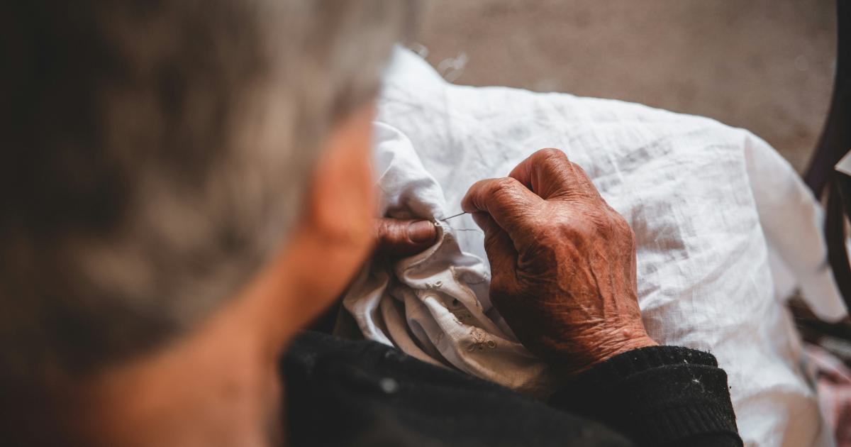Personne âgée assise sur un lit avec des douleurs aux genoux