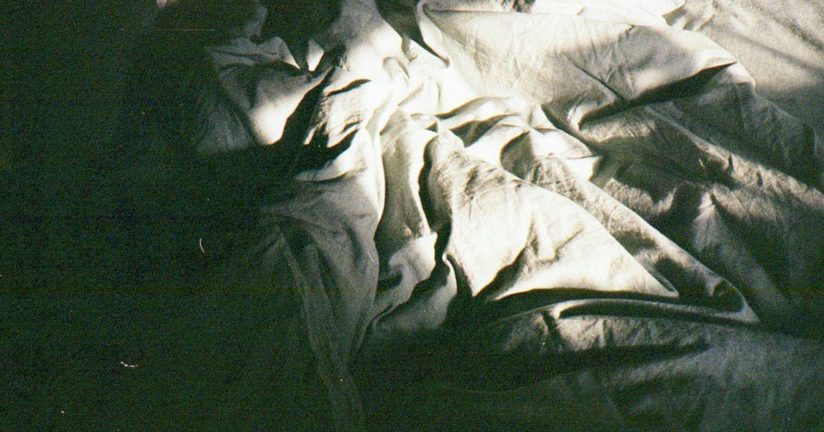 Homme endormi sur un matelas, gros plan sur son dos